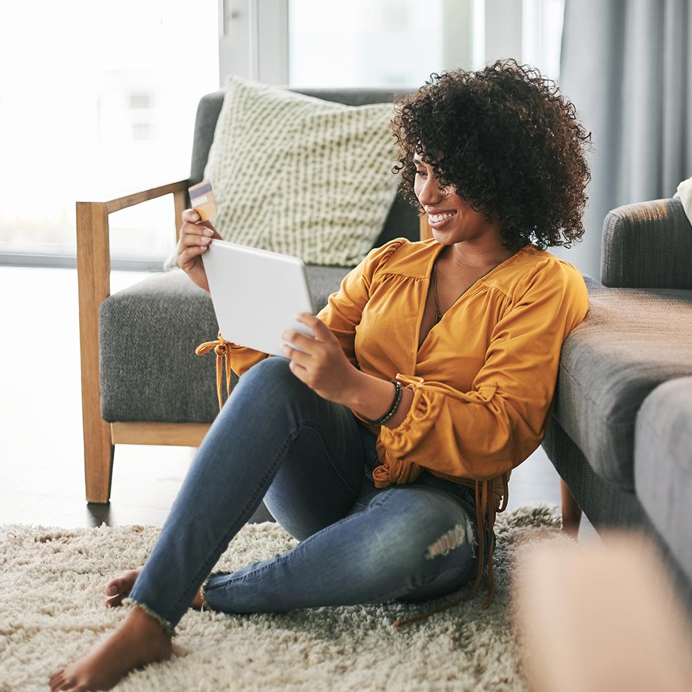 Woman sitting on floor looking at tablet